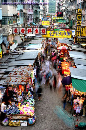 Backpackers Bartering in a Hong Kong Street Market