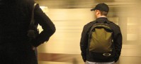 Guy in hat wearing a backpack in the subway